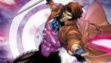 Cover of Gambit: Wanted #1 showing Gambit leaping forward with his staff, surrounded by glowing pink kinetic energy and oversized playing cards. He wears his signature trench coat and purple armor against a dark city backdrop, with the title in large pink lettering at the top.